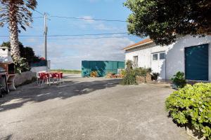 a house with a table and chairs in a driveway at Casa Campo e Mar in Encarnação