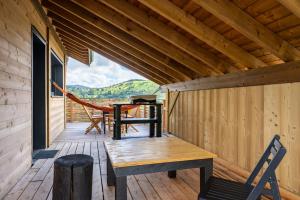 a wooden porch with a table and chairs on it at Le chalet Amélie in La Bresse