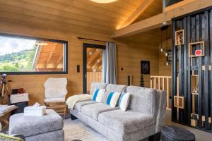 a living room with a couch and a chair at Le chalet Amélie in La Bresse