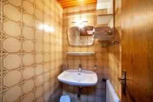 a small bathroom with a sink and a mirror at Rieglhof Apartment Kükennest in Curon Venosta +11 photos