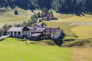 an aerial view of a large house in a field at Rieglhof Apartment Kükennest in Curon Venosta