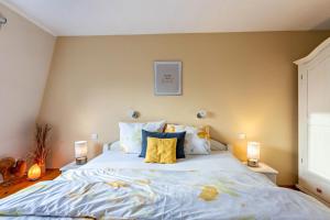 a bedroom with a large bed with pillows at Haevn-Erholung, Fewo Südsonne in Reußenköge