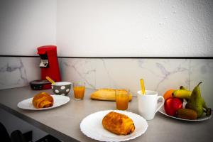 a table with two plates of food and fruit at Plage et Soleil Parking Privé Piscine Plage à 5 min in La Grande Motte