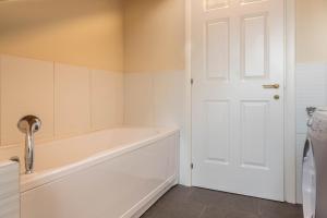 a bathroom with a tub and a white door at Maison Vittoria Lago Maggiore in Laveno-Mombello +19 photos