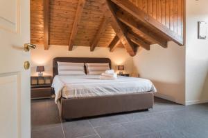 a bedroom with a large bed with wooden ceilings at Maison Vittoria Lago Maggiore in Laveno-Mombello
