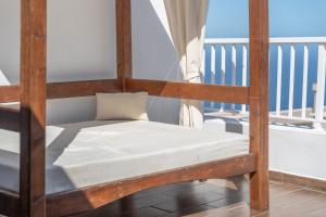 a wooden bunk bed with white sheets on a balcony at Las Cucharitas in La Guancha