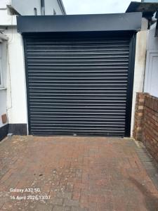a large metal garage door on the side of a building at Christian Guest House 1 in Luton +24 photos