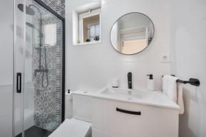 a white bathroom with a sink and a mirror at Casa Abuela Maria in Jerez +19 photos