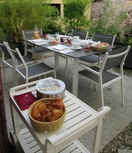 a white table with a basket of food on it at Cour Du Weinhof à Colmar in Colmar