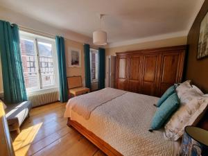 a bedroom with a bed with blue pillows on it at Cour Du Weinhof à Colmar in Colmar