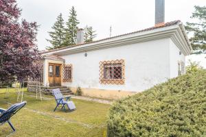 a white house with two chairs in the yard at El chalet El uncar in Castrejón de la Peña