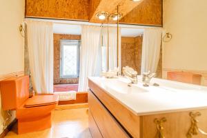 a bathroom with a sink and a toilet and a mirror at El chalet El uncar in Castrejón de la Peña