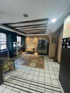 a living room with a tv and a tiled floor at Hostal Rey Pedro I in Santo Domingo de la Calzada