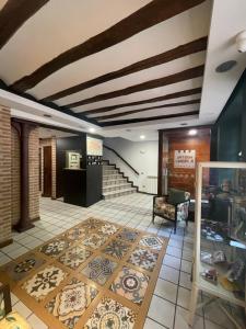 a lobby with a tile floor and stairs with a rug at Hostal Rey Pedro I in Santo Domingo de la Calzada