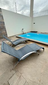 two empty chairs in front of a swimming pool at Casa em tibau in Tibau
