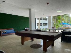 a pool table in a room with a green wall at Apartments Miami in Sunny Isles Beach