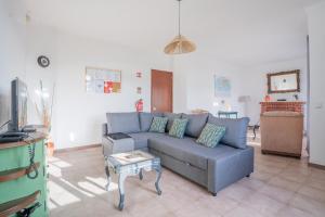 a living room with a blue couch and a table at Casa das 3 Marias in Biscoito Bravo
