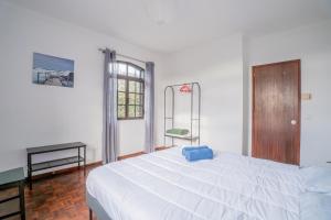 a bedroom with a large white bed and a window at Casa das 3 Marias in Biscoito Bravo