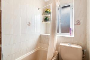 a bathroom with a tub and a toilet and a window at Siempreviva in Gáldar +29 photos