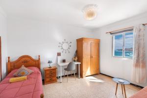 a bedroom with a bed and a desk and a window at Siempreviva in Gáldar