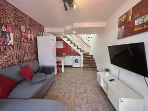a living room with a couch and a flat screen tv at Dunaflor Gemelo 2 in San Bartolomé