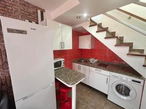 a kitchen with a washing machine and a staircase at Dunaflor Gemelo 2 in San Bartolomé
