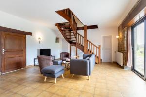 a living room with chairs and a spiral staircase at La longère familiale et authentique in Melgven