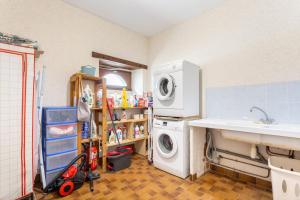 a laundry room with a washing machine and a sink at La longère familiale et authentique in Melgven +24 photos