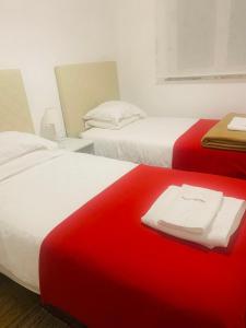 two beds in a room with red and white at Casa Jubileu in Golegã