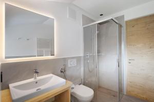 a bathroom with a toilet and a sink and a shower at Premium App Hofer Heidi in Villabassa +21 photos
