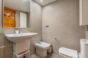 a bathroom with a sink and a toilet and a mirror at El Tesorillo Andalúz in Almuñécar +17 photos