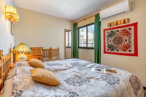 a bedroom with a large bed and a window at El Tesorillo Andalúz in Almuñécar