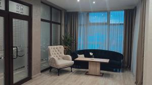 a living room with a couch and a chair and a table at Maribel Spa Hotel in Köprilova