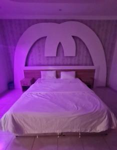 a bedroom with a large bed with a purple lighting at شاطئ الحوية in Taif