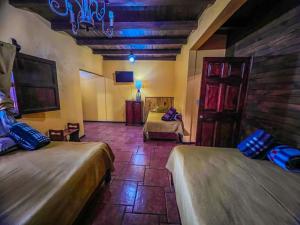 a room with two beds and a tv in it at Villas Lupita in Mazamitla
