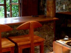 a wooden bar with a wooden chair at a table at CABAÑA vacacional in Temblador