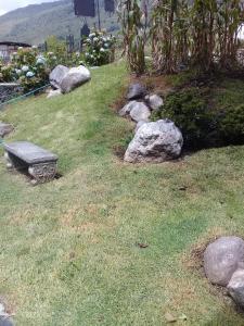 a garden with rocks and a bench in the grass at CABAÑA vacacional in Temblador