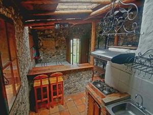 a kitchen with a stove and a counter with stools at CABAÑA vacacional in Temblador