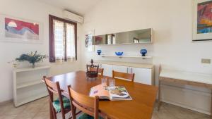 a kitchen and dining room with a wooden table and chairs at Blue Horizon Sinis in Funtana Meiga