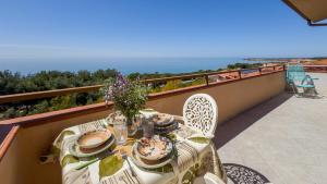 a table on a balcony with a view of the ocean at Blue Horizon Sinis in Funtana Meiga