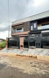 a large building with black doors and aphalt at Casa Centro de Socorro prox a Feira de malhas in Socorro