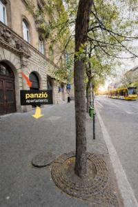 a tree on the side of a street with a parking meter at Panzió Apartments in Budapest