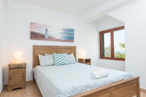 a bedroom with a bed and a window and a lighthouse at Can Divertit in Port de Soller +19 photos