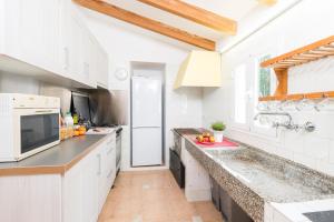 a kitchen with white cabinets and a counter top at Can Divertit in Port de Soller