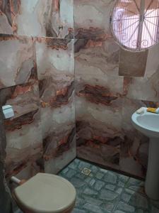 a bathroom with a toilet and a sink at Pousada Vó Ana Reis in Aparecida