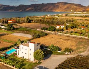 an aerial view of a house next to the water at Martimi Private 3 Apartments with Pool, Heated Jacuzzi and Sauna, 2 Apartments with Sea View, 200m from Beach, BBQ, Playground, Mini Football Pitch in Kissamos
