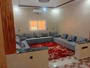 a living room with a couch and a red carpet at شقة الياس in Agdz