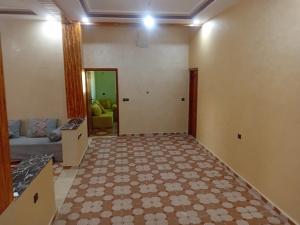 a living room with a couch and a tile floor at شقة الياس in Agdz