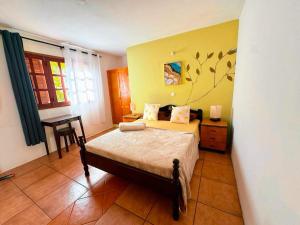 a bedroom with a bed and a desk in it at Divin'Art in Tarrafal da Vila de Ribeira Grande