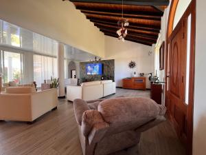 a living room with a couch and a tv at Villa Edén Alto in La Tebaida